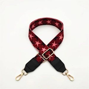 Detail showing adjustable red woven strap with star patterns and gold metal clasps