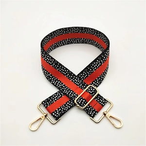 Adjustable black and white pixelated woven strap with red stripes and gold metal hooks
