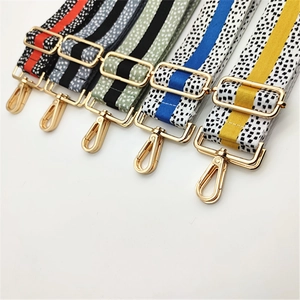 Close-up of five colorful adjustable patterned shoulder straps with gold metal buckles