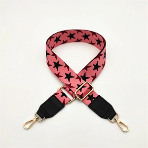 Detail of adjustable pink star pattern shoulder strap with golden lobster clasps