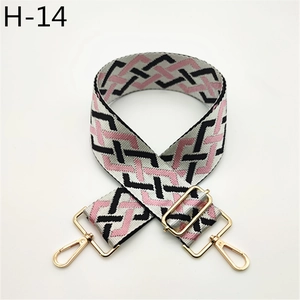 Close-up of pink and grey geometric woven wide shoulder strap with gold metal buckles