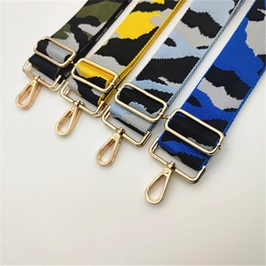 Detailed close-up of adjustable camo canvas bag straps with golden metal swivel hooks