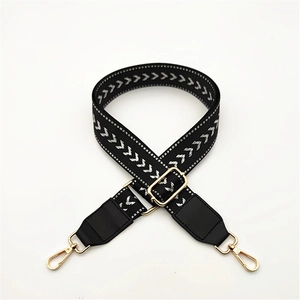 Adjustable woven purse strap with black and white V-pattern and gold metal lobster clasps
