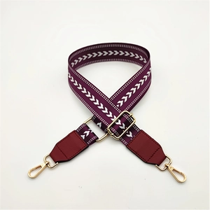 Detail of purple woven strap with white chevron patterns and gold metal lobster clasps