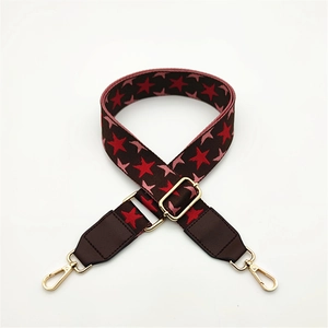 Detail of star pattern woven shoulder strap with brown PU leather and gold buckle