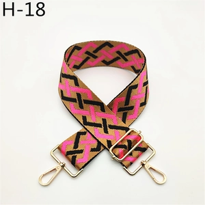 Close-up of pink and black checkered wide bag strap with gold metal swivel hooks
