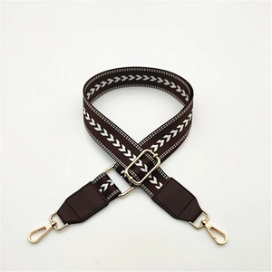 Brown wide purse strap with white herringbone pattern and gold metal lobster clasps