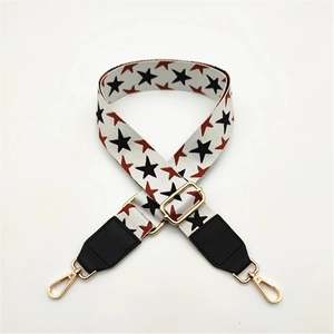 Detail of adjustable star pattern woven bag strap with black leather ends and gold buckles