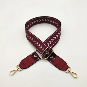 Adjustable burgundy shoulder strap with white chevron pattern and gold metal lobster clasps