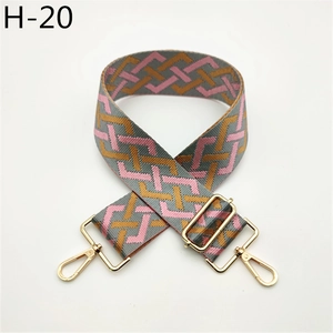 Close-up of pink and brown geometric woven bag strap with gold lobster clasps and metal hardware