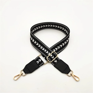 Detail of adjustable black and white herringbone woven strap with gold metal lobster clasp