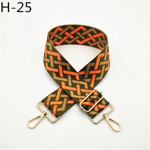 Close-up of adjustable woven shoulder strap with geometric patterns and gold metal hooks