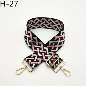 Detailed view of adjustable geometric pattern woven strap with light gold metal hardware