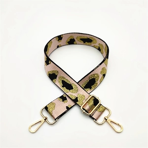 Macro view of leopard print adjustable bag strap with gold metal lobster clasps