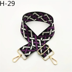 Detail view of adjustable purple woven strap with geometric patterns and gold metal buckles