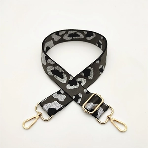 Detail of adjustable leopard print bag strap with golden metal lobster clasps and buckles