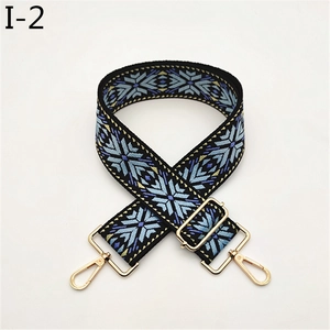 Detail of adjustable wide bag strap with colorful jacquard snowflake pattern and gold hardware
