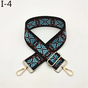 Detailed view of woven geometric wide strap with adjustable gold metal lobster clasps