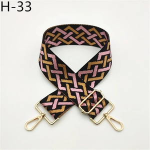 Detail view of ethnic geometric adjustable woven bag strap with golden metal swivel hooks