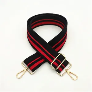 Detail of adjustable black and red striped bag strap with gold metal rotating clasps