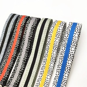Détail de bandoulières de sac tissées aux motifs rayés et mouchetés en diverses couleurs
