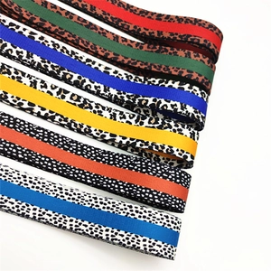 Close-up of leopard print and polka dot adjustable nylon straps with colorful stripes