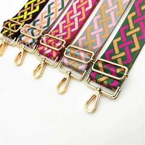 Detail of adjustable wide purse straps with geometric jacquard and gold hardware