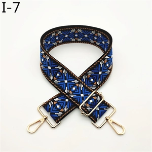 Close-up of adjustable wide bag strap with colorful geometric jacquard and gold metal hooks