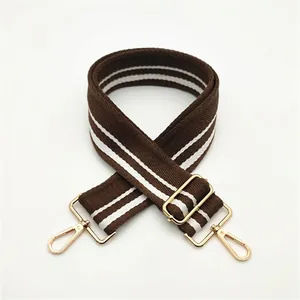 Detail of adjustable coffee and white striped canvas strap with golden metal hooks