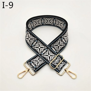 Close-up of snowflake pattern woven bag strap with golden adjustable metal buckle