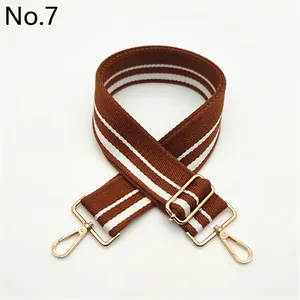 Close-up of brown and white striped fabric strap with golden metal swivel hooks