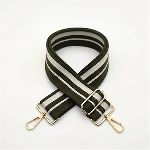 Detail of adjustable olive and beige striped wide canvas strap with gold metal hooks