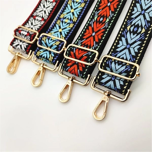 Detail view of colorful woven bag straps with geometric patterns and golden metal buckles