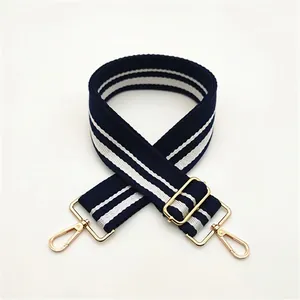 Detail of blue and white striped canvas strap with adjustable golden metal buckles