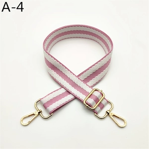 Close-up of pink and white striped woven bag strap with golden lobster clasps