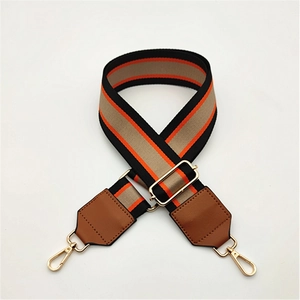 Adjustable striped canvas bag strap with gold metal hooks and brown leather ends