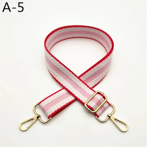 Detail view of red, pink, and white striped strap with polished gold metal swivel hooks