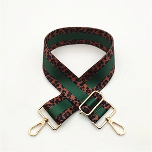 Detail of adjustable leopard print bag strap with green stripes and gold metal hardware