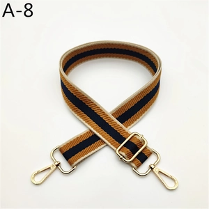 Detail of adjustable canvas strap with navy, yellow stripes and gold metal buckles