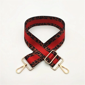 Detail of adjustable leopard print bag strap with red stripes and gold metal lobster hooks