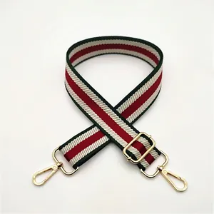 Close-up of red and green striped replacement shoulder strap with gold swivel metal hooks
