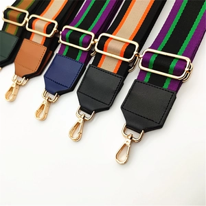 Close-up of adjustable striped canvas bag straps with PU leather ends and gold metal hooks