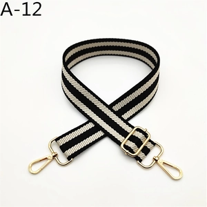 Detail of nylon woven handbag strap with black and white stripes and gold hooks