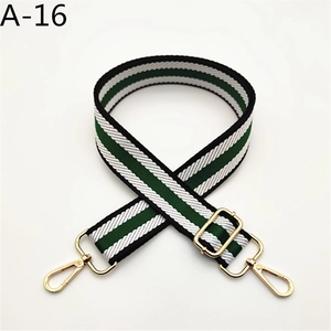 Close-up of adjustable green and white striped woven bag strap with gold metal buckle hardware