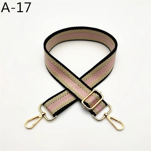 Detail of adjustable striped nylon shoulder strap with golden metal hooks for handbags