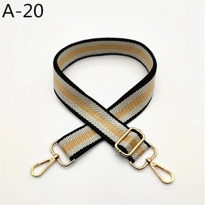 Close-up of adjustable black white gold striped bag strap with shiny gold lobster clasps