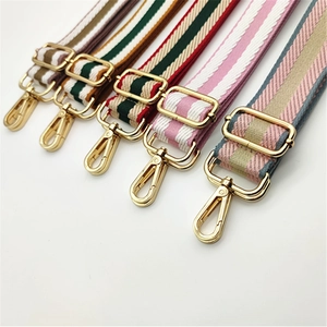 Detail of adjustable woven nylon bag straps with golden alloy buckles in various stripe patterns