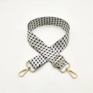 Close-up of adjustable strap with geometric pattern and gold-tone metal hooks