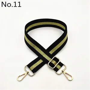 Detail view of adjustable black and green striped shoulder strap with gold metal buckle