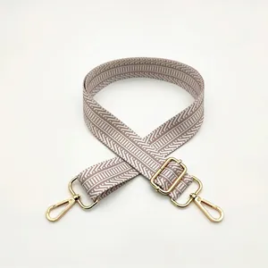Adjustable beige and brown geometric patterned bag strap with golden metal swivel hooks